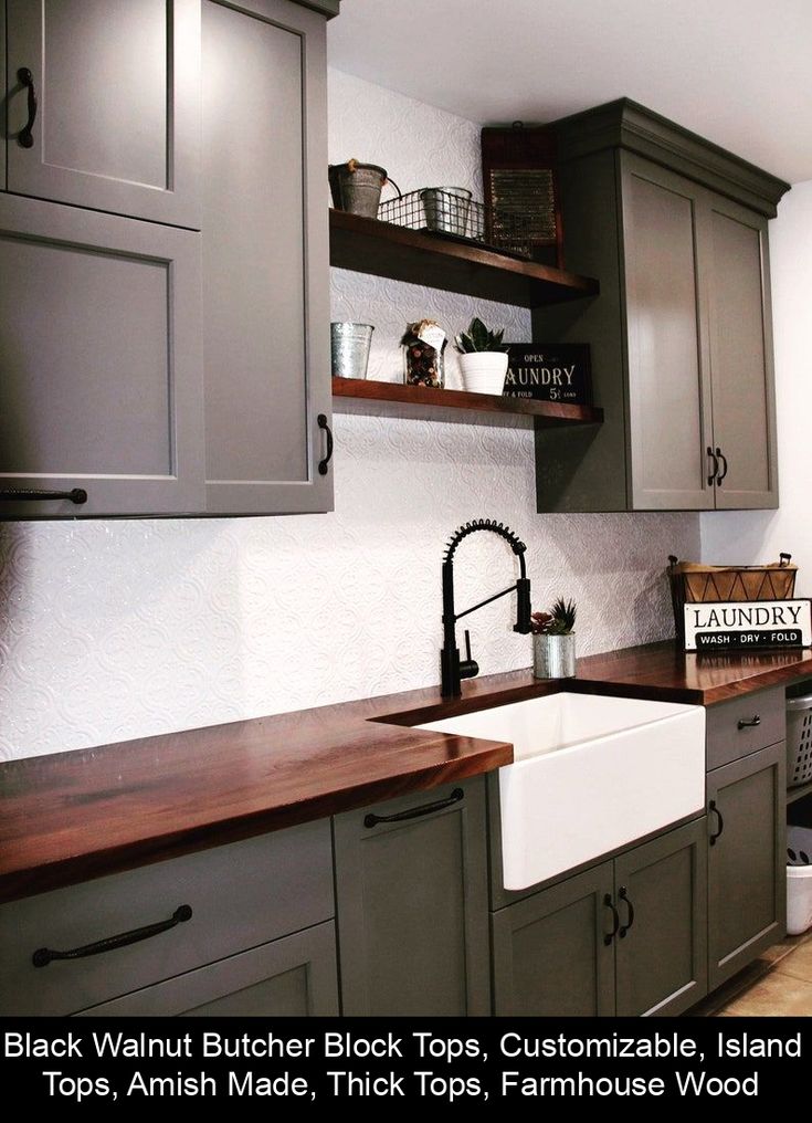 a kitchen with gray cabinets and wooden counter tops