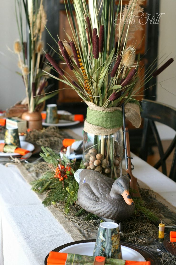 the table is set for thanksgiving dinner with turkeys and grasses in mason jars on it