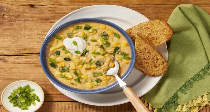 a bowl of soup with bread and sour cream