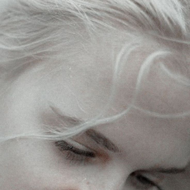 a close up of a person with white hair