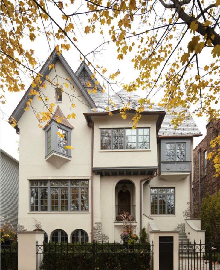 a large white house with lots of windows on it's front porch and fence