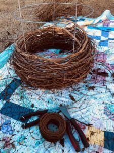 a bird nest sitting on top of a table next to some scissors and wire wrapped around it