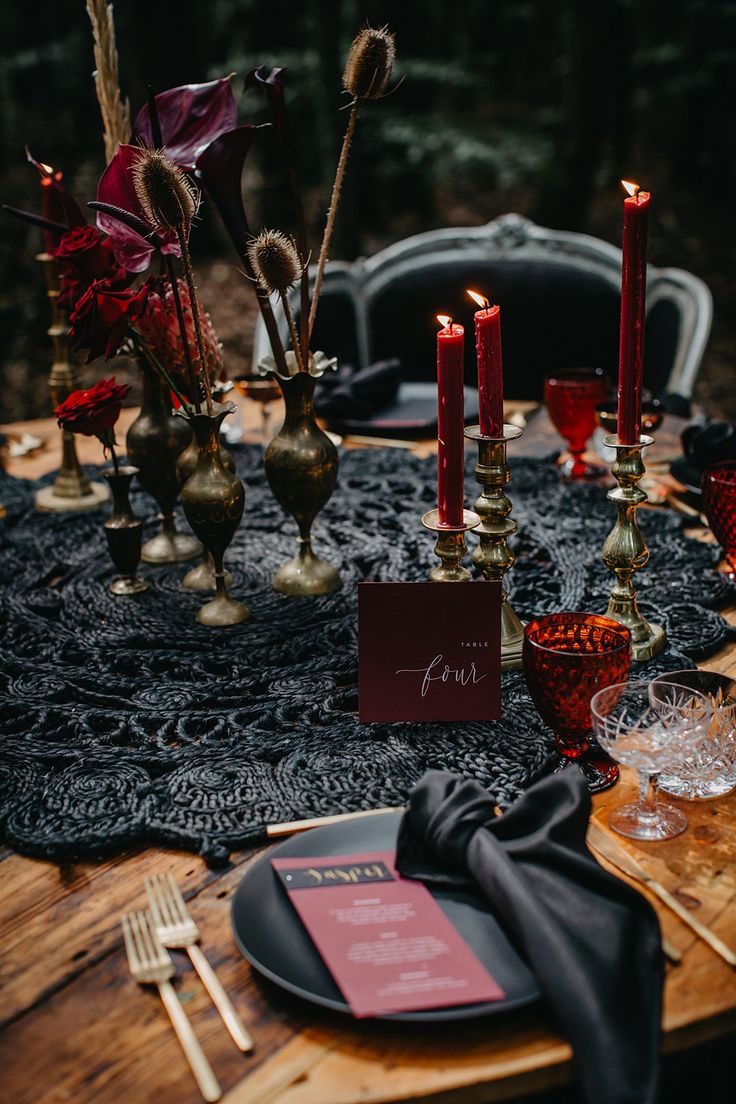 the table is set with candles, place settings and menu cards for guests to eat