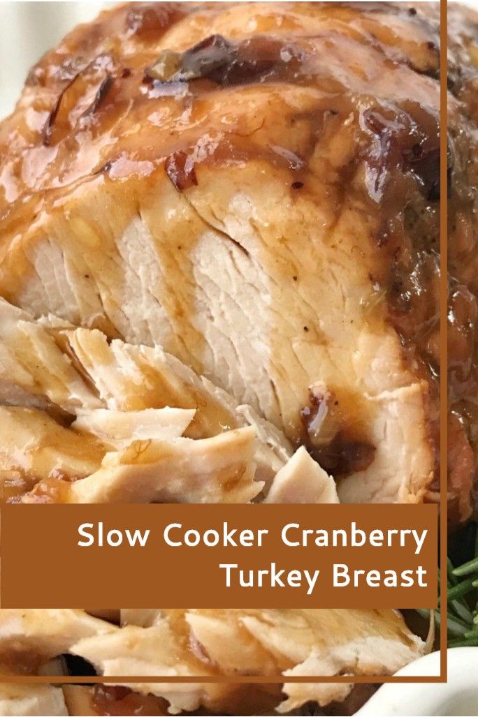 slow cooker cranberry turkey breast on a white platter with rosemary sprigs