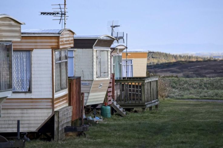 several mobile homes are lined up on the grass