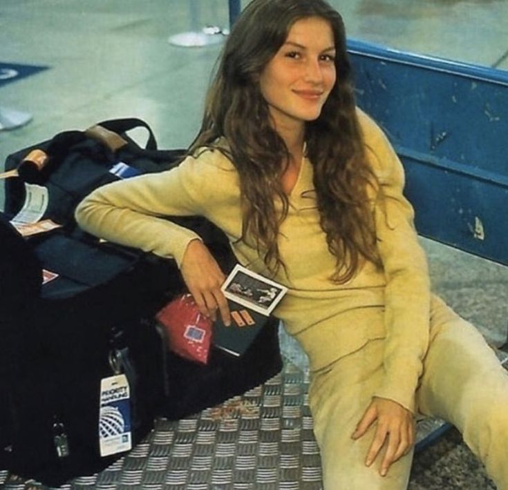 a woman sitting on the ground next to luggage