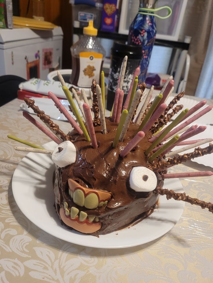 a cake decorated to look like a hedgehog with candles sticking out of its mouth