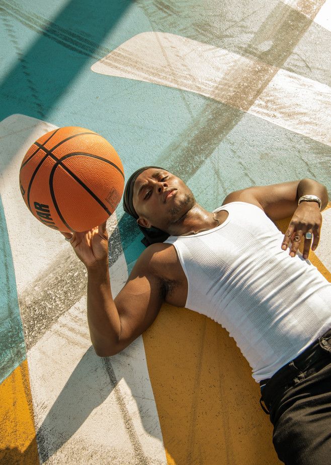 a man laying on the ground holding a basketball