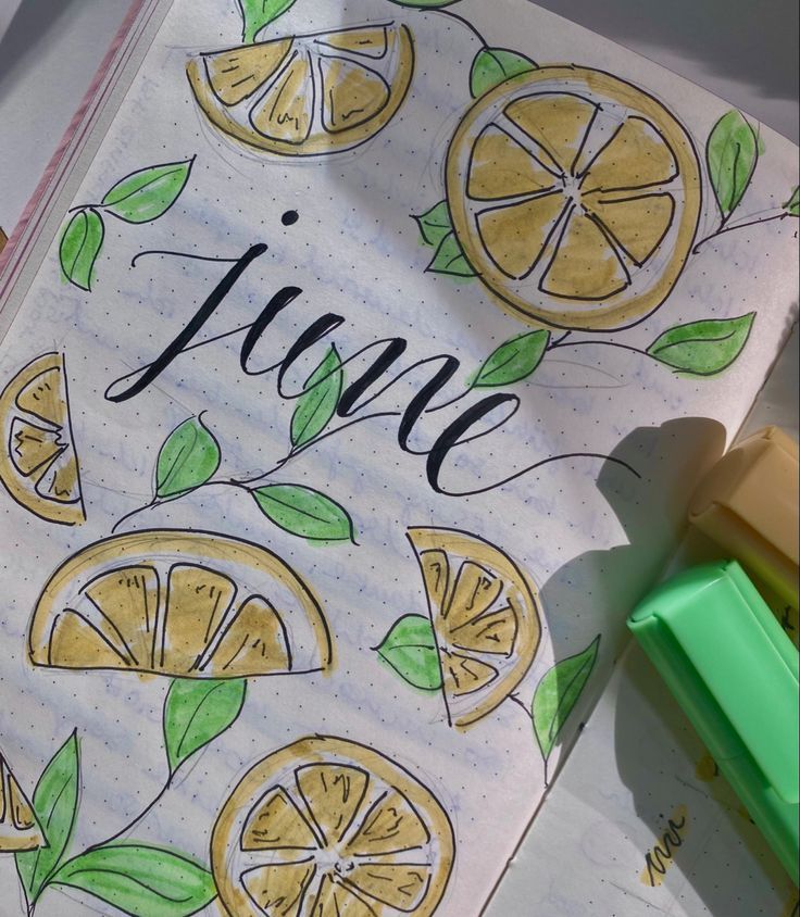 an open notebook with lemons and the word june written in cursive writing