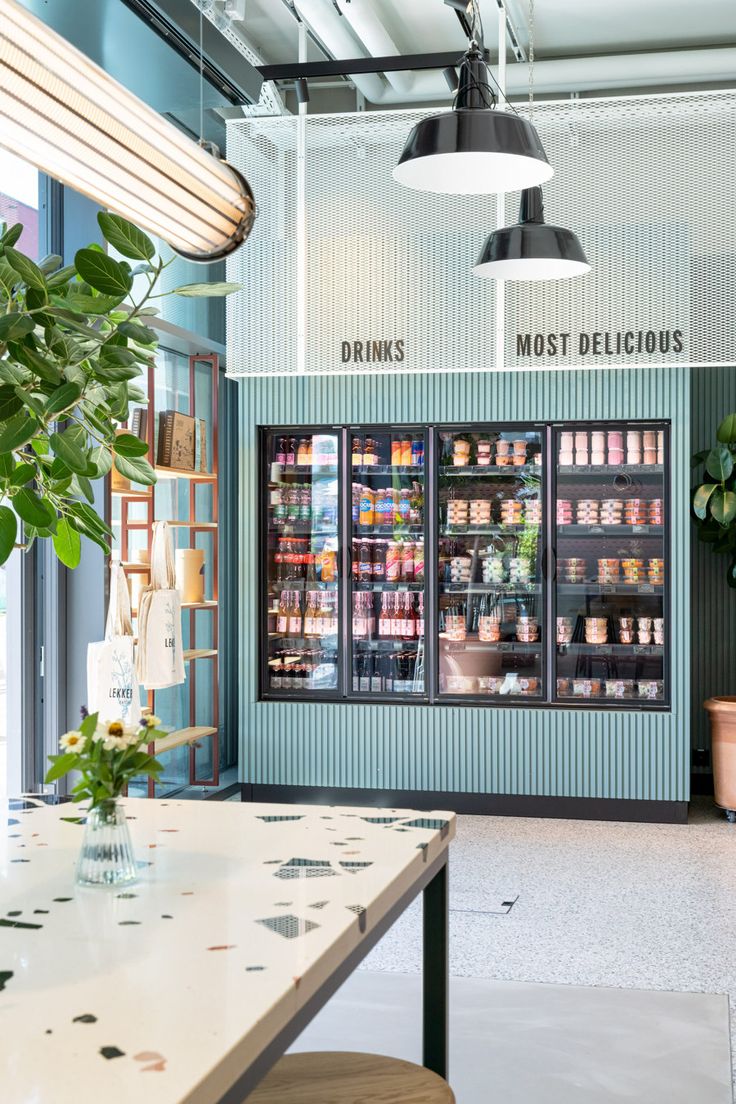 the interior of a store with plants and food in it's display cases,