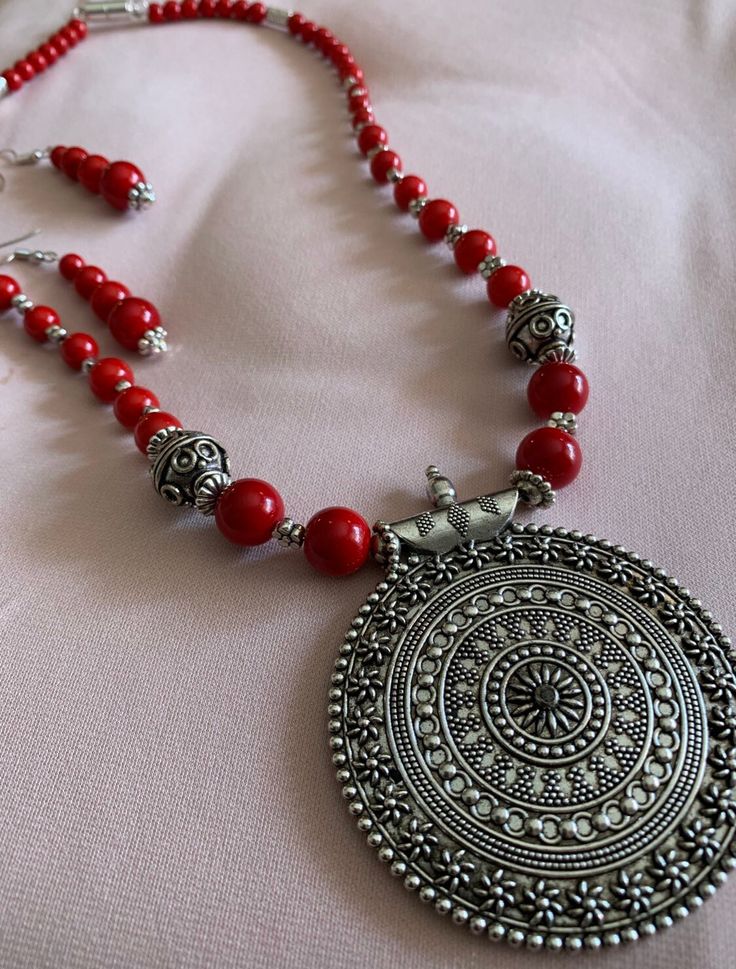 A stunningly ornate, imported locket serves as the centerpiece of this eye-catching necklace with fire engine red beads and silver embellishments; with matching earrings; Beaded Jewelry Designs, Fire Engine, Red Bead, Matching Earrings, Locket, Jewelry Sets, Beaded Jewelry, Beaded Necklace, Jewelry Design