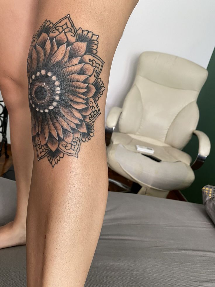 a woman's leg with a sunflower tattoo on it