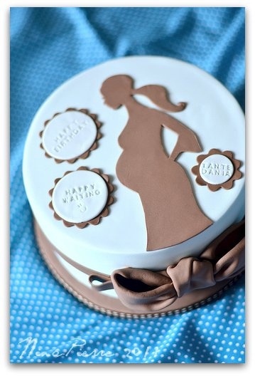 a cake decorated with a silhouette of a woman and baby's name on it