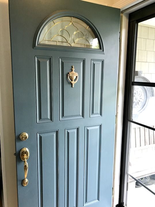 the front door is painted blue and has gold hardware on it's side panel