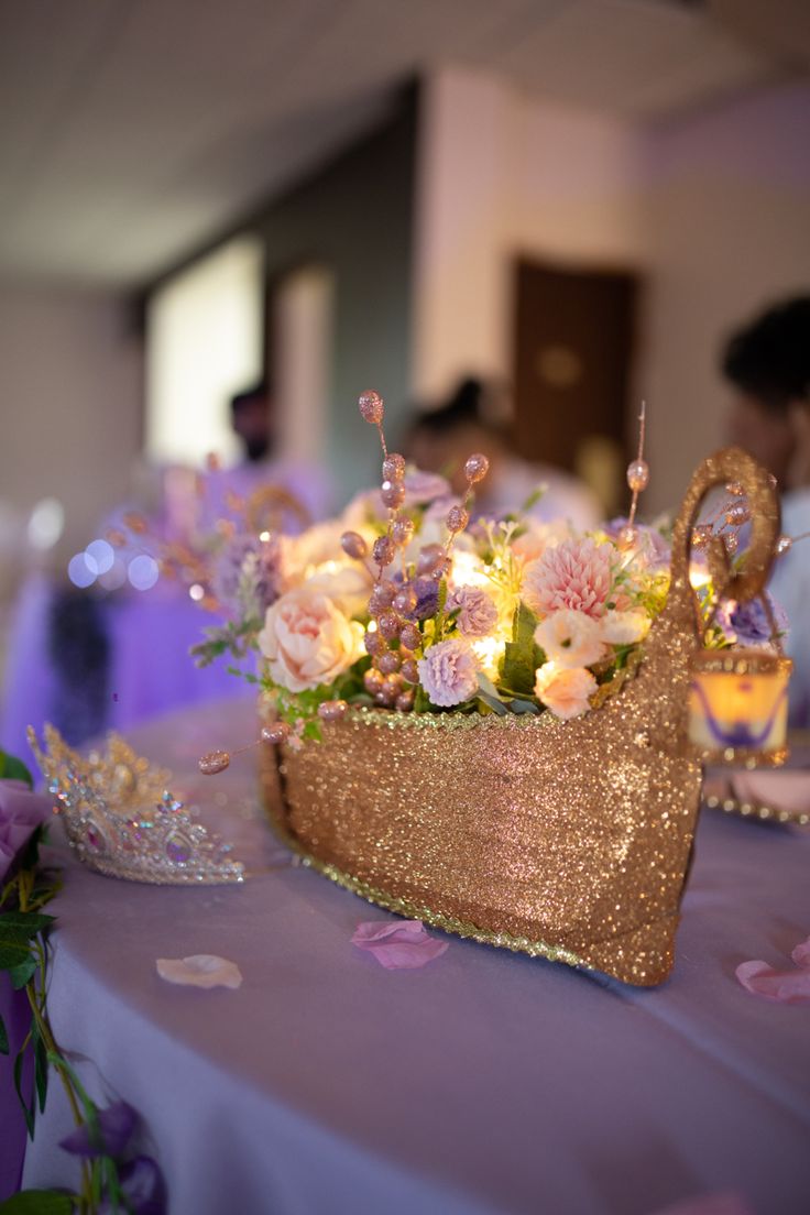 a basket filled with flowers sitting on top of a purple table covered in confetti