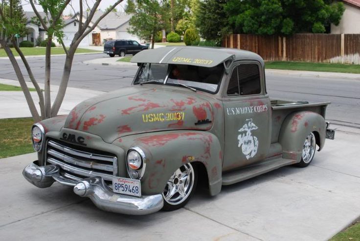 an old truck with blood all over it parked on the side of the road in front of a house