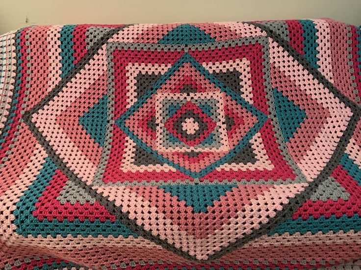 a crocheted blanket is laying on the floor