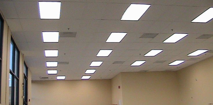 an empty room with several square lights on the ceiling and some boxes in the floor