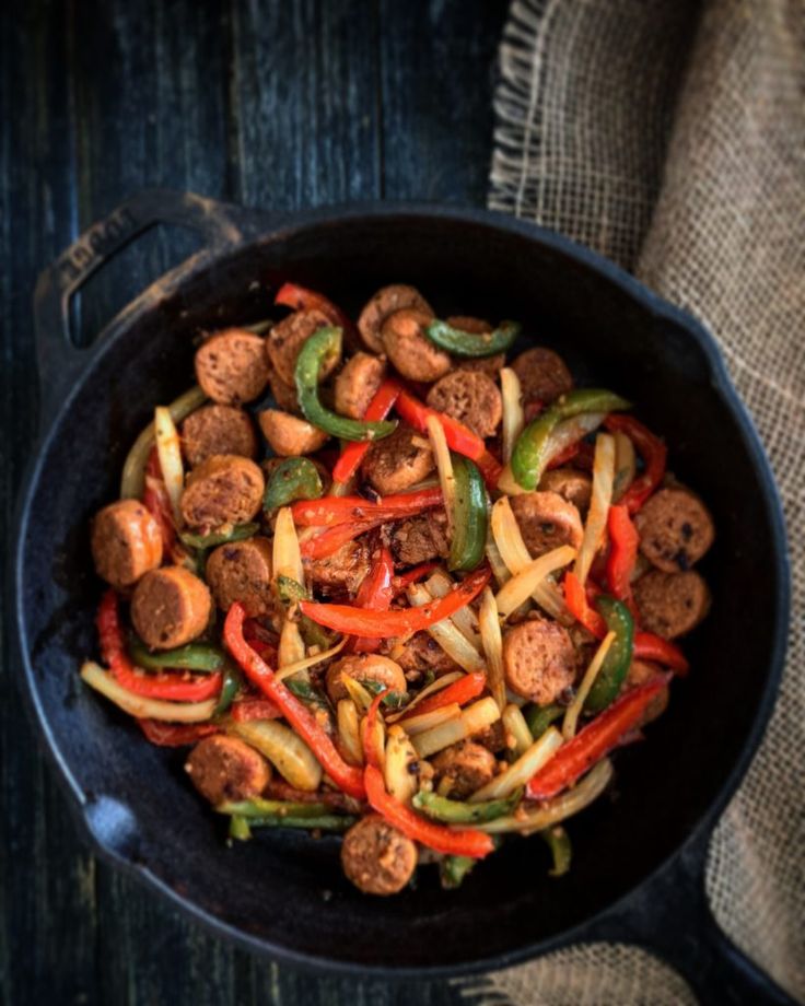 a skillet filled with sausage and peppers