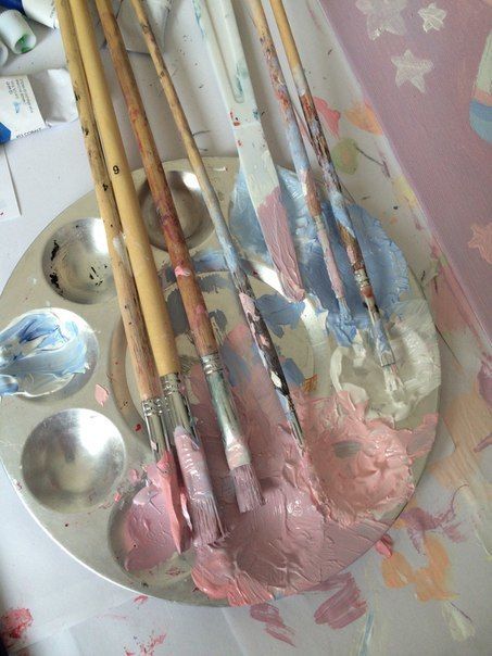 some paint brushes and spoons on a plate