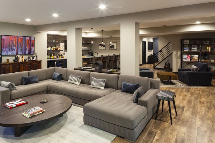 a living room filled with lots of furniture and decor on top of a hard wood floor