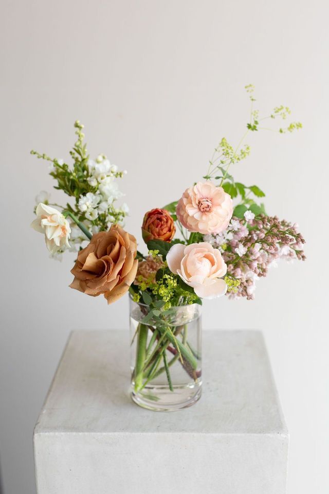 a vase filled with lots of flowers on top of a table