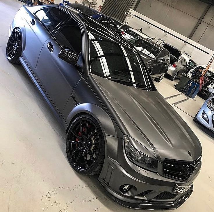 a silver car parked in a garage next to other cars