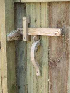 a close up of a door handle on a wooden fence with wood boards in the background