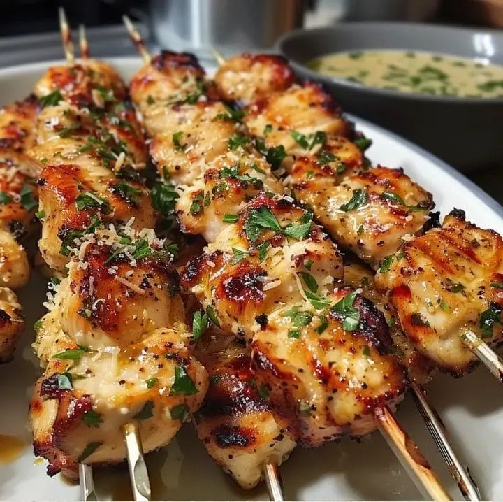 some chicken skewers are sitting on a plate