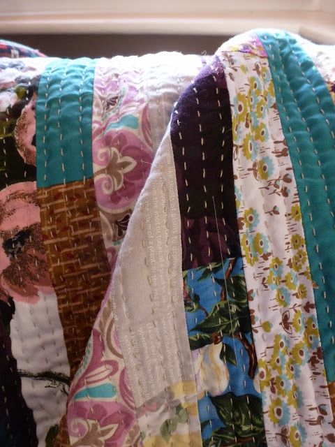 a close up of a quilted pillow on a window sill