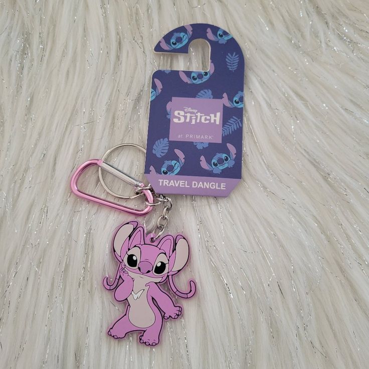 a pink keychain with an elephant on it and a tag attached to it