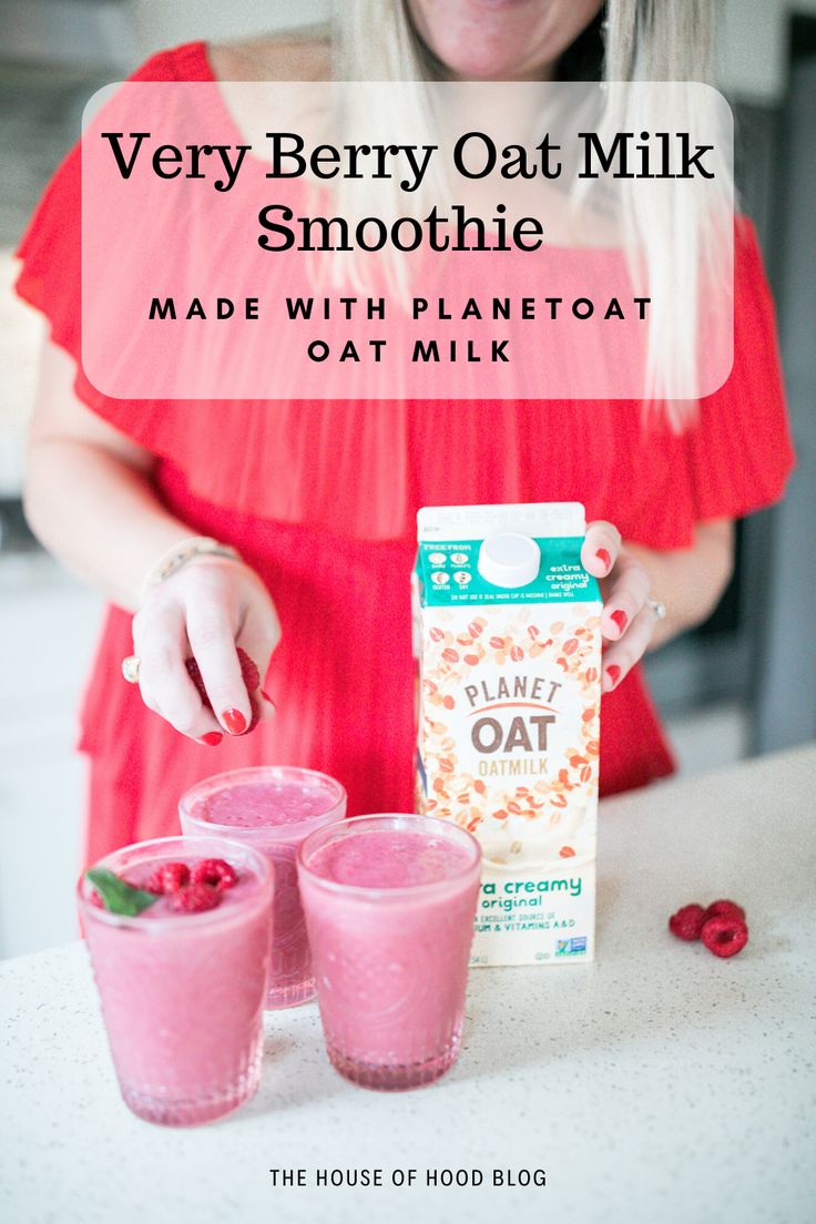 a woman standing in front of a box of oat milk next to two cups with raspberries