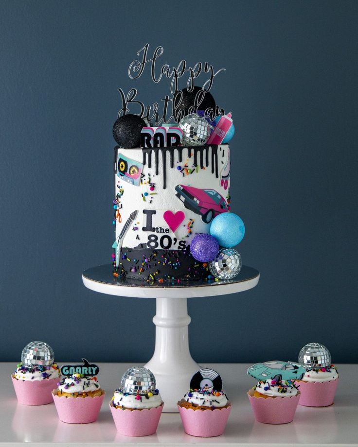 a birthday cake and cupcakes on a table