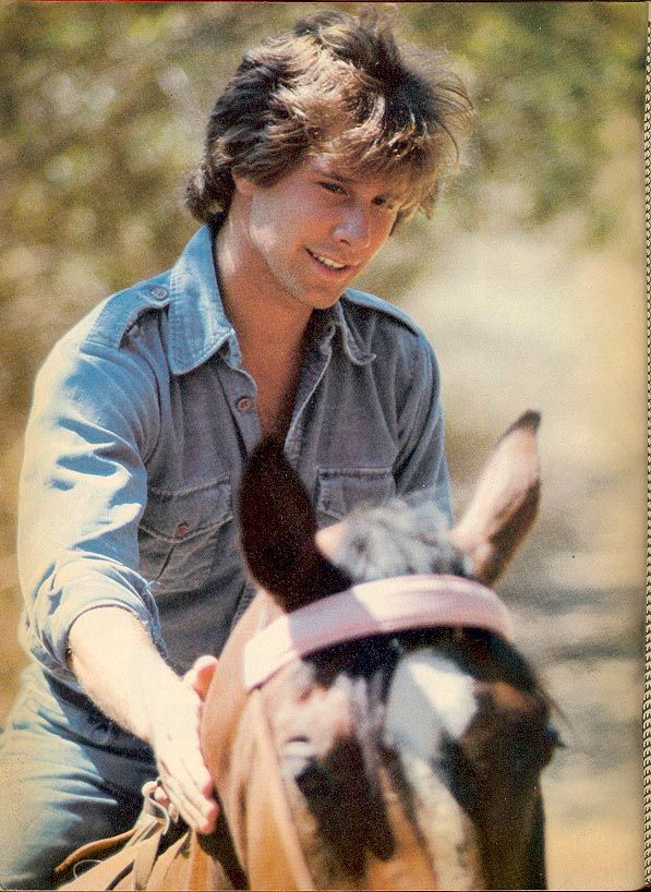 a young man riding on the back of a brown horse