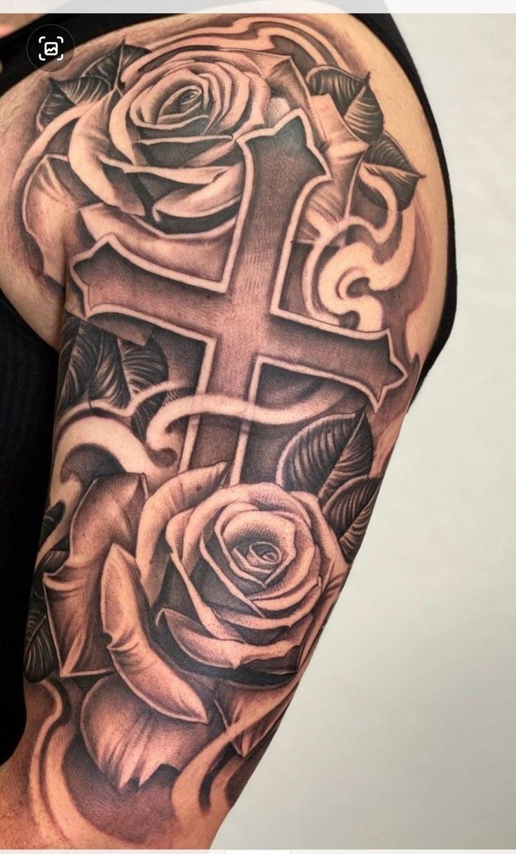 a cross and roses tattoo on the arm