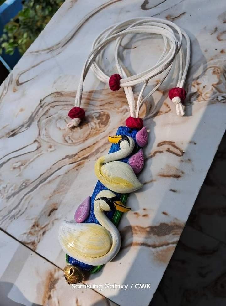 a necklace made out of shells on a marble slab with cords attached to the beads