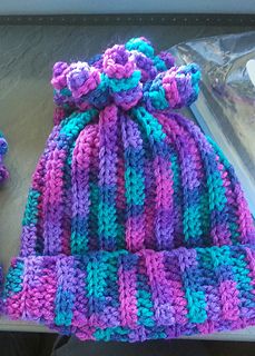 a crocheted hat and mittens sitting on top of a table