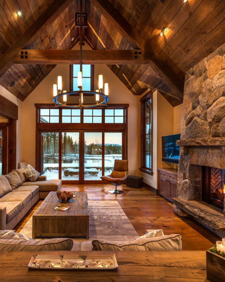 a living room filled with lots of furniture and a fire place in front of a stone fireplace