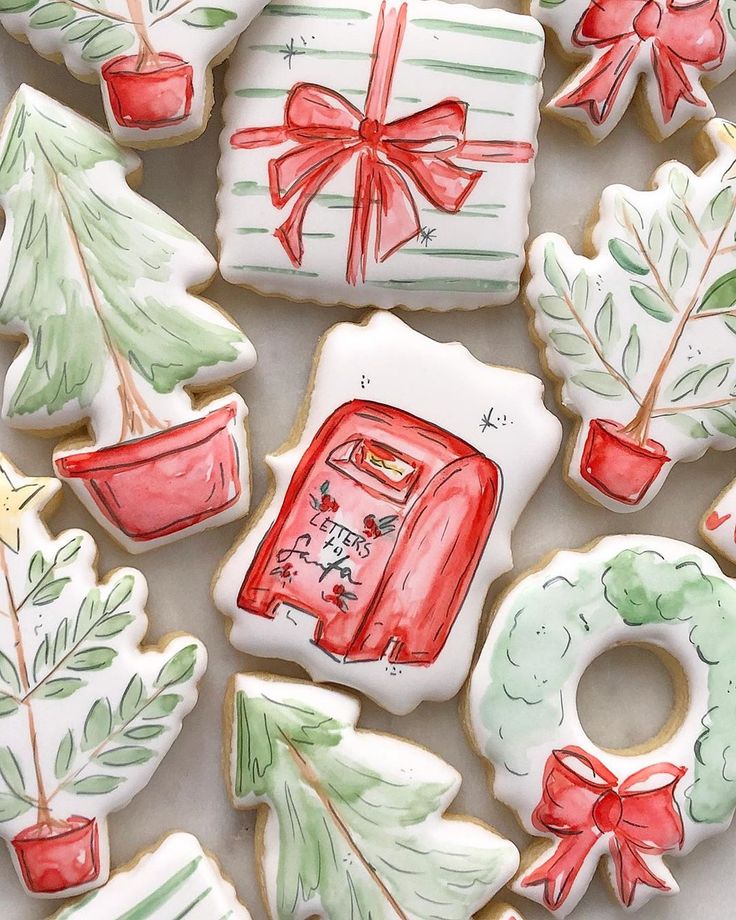 christmas cookies decorated with hand painted designs and bows are displayed on a white tablecloth