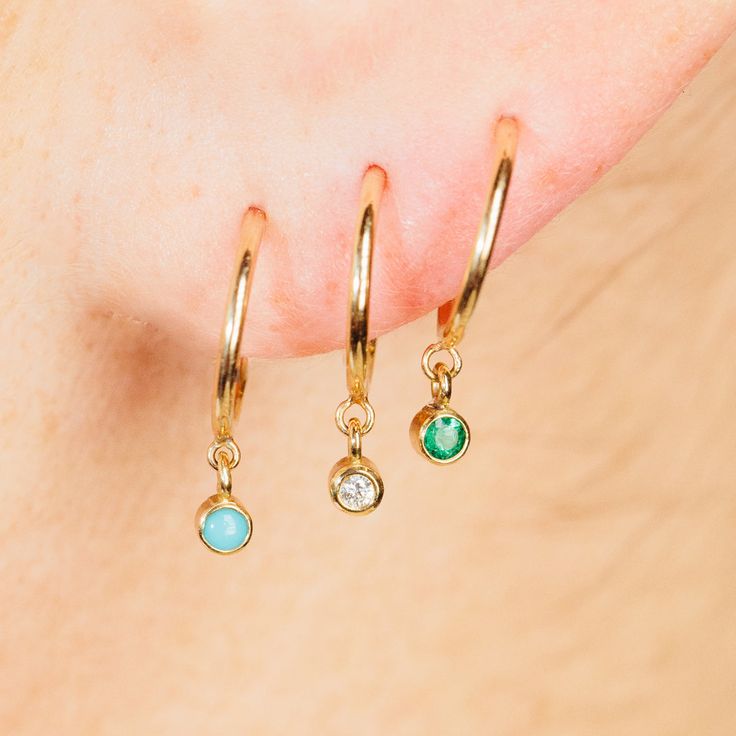 14k gold tiny huggie hoop earrings with bezel set round emeralds dangling from the bottom SPECIFICS • hoops are approx. 10mm• emerald stones are approx. 2mm each• sold as pair or single Yellow Gold Sterling Silver Huggie Earrings With Birthstone, Everyday Jewelry With Bezel Setting For May Birthstone, Fine Jewelry Huggie Earrings With Birthstone, 14k Gold Huggie Jewelry With Bezel Setting, Yellow Gold Huggie Earrings Gift, Sterling Silver Hoop Earrings For May Birthstone, Yellow Gold Huggie Earrings With Bezel Setting As Gift, Everyday Yellow Gold Huggie Earrings With Birthstone, Round Bezel Setting Huggie Earrings