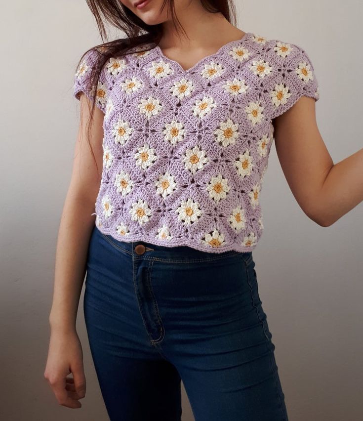 a woman wearing a purple crochet top with daisies on the front and sides