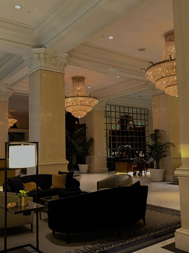 an elegant lobby with chandeliers and couches