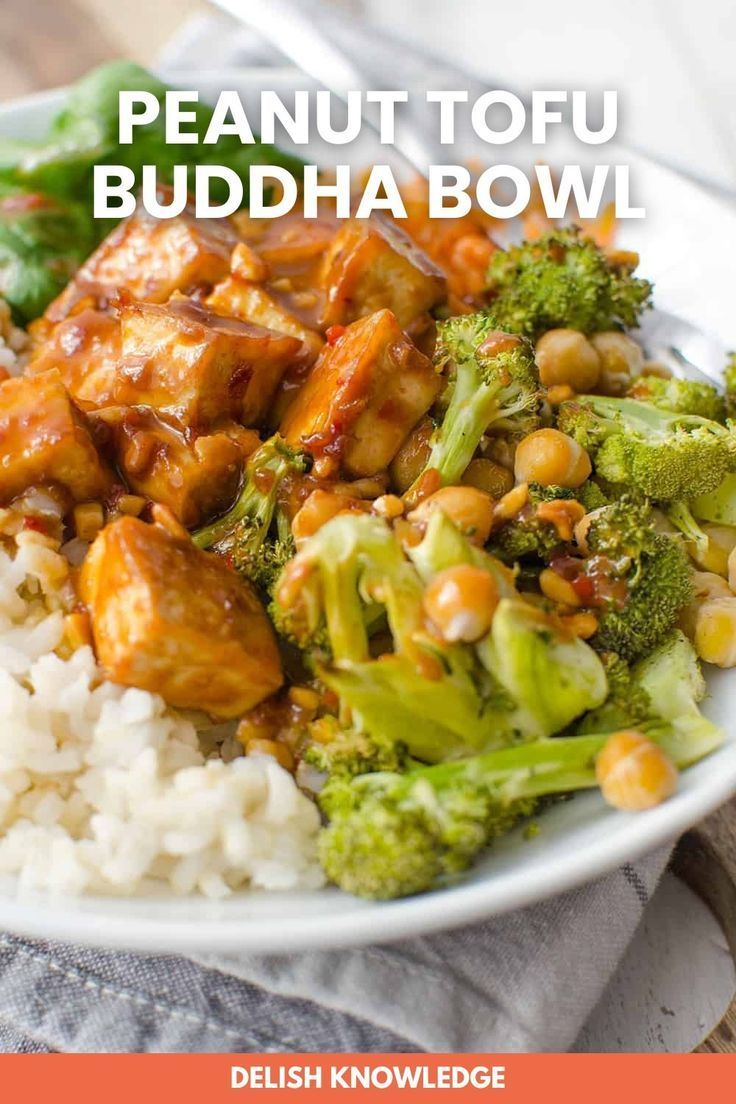 a white plate topped with rice and broccoli covered in peanut tofu buddha bowl