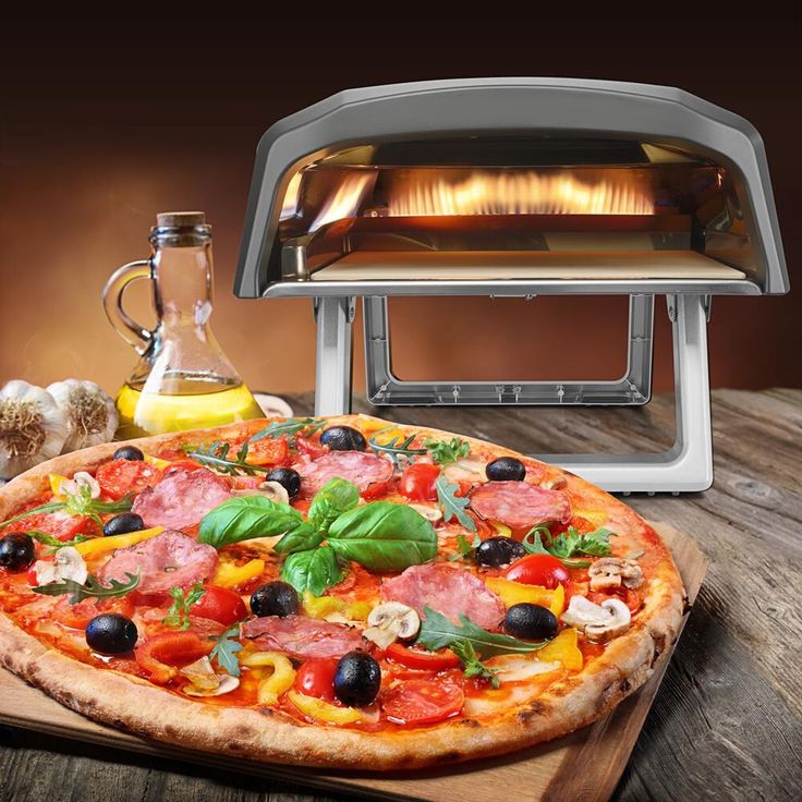 a pizza sitting on top of a wooden cutting board next to an open fire oven