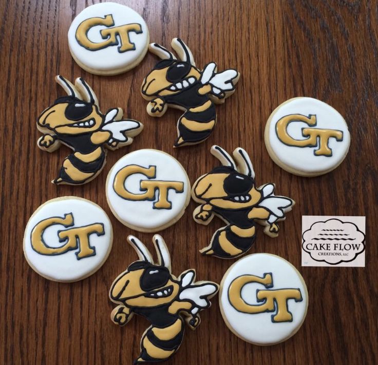 six decorated cookies with the letter g on them are sitting on a wooden table next to each other