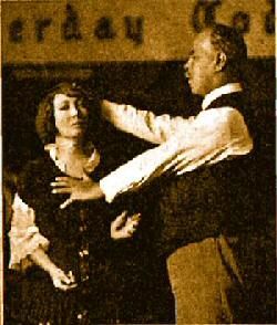 an old black and white photo of a man holding a woman's arm in front of him