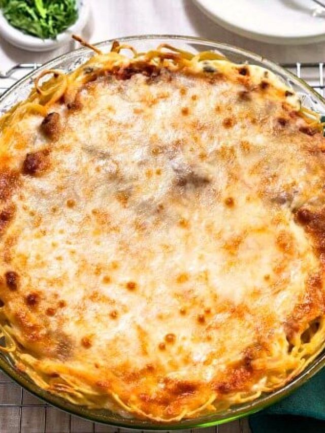 a casserole dish with cheese and sauce in it sitting on a cooling rack