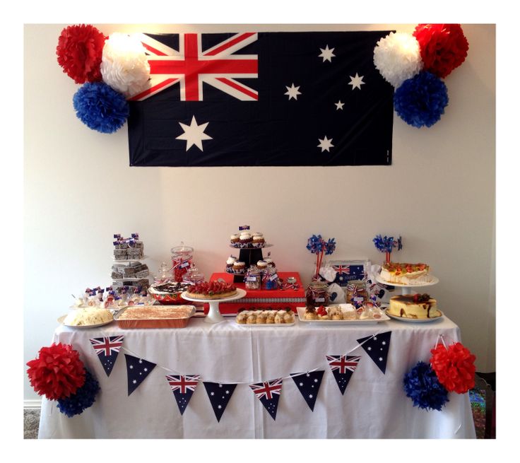 a table topped with cake and desserts next to an australian flag hanging on the wall