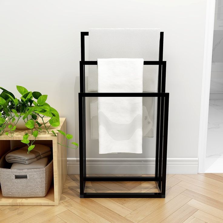 a stack of towels sitting on top of a wooden shelf next to a plant