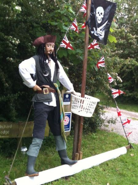 a man in pirate costume standing next to a flag pole